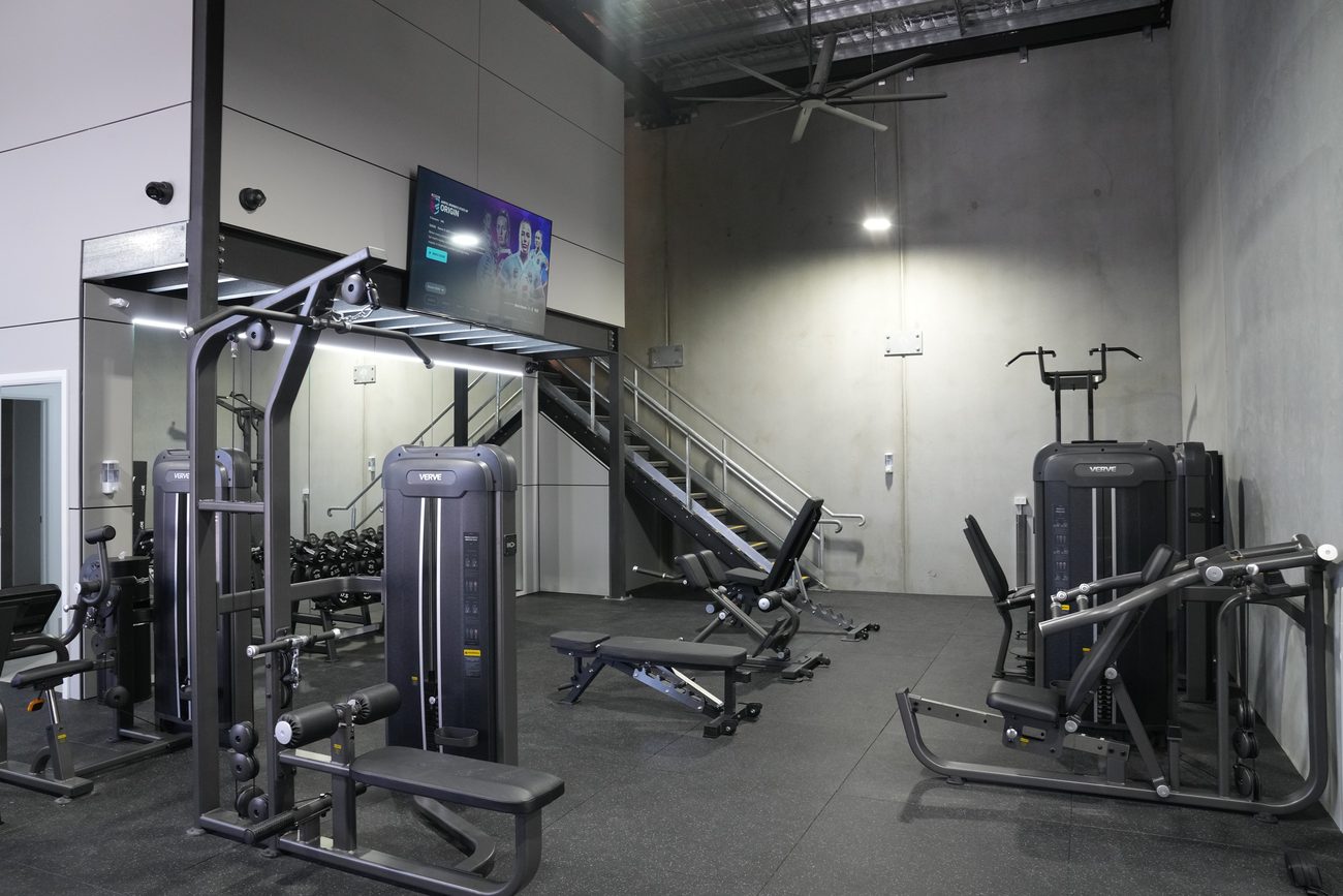 Pin-loaded machines and adjustable benches beneath the Synergy RX mezzanine.